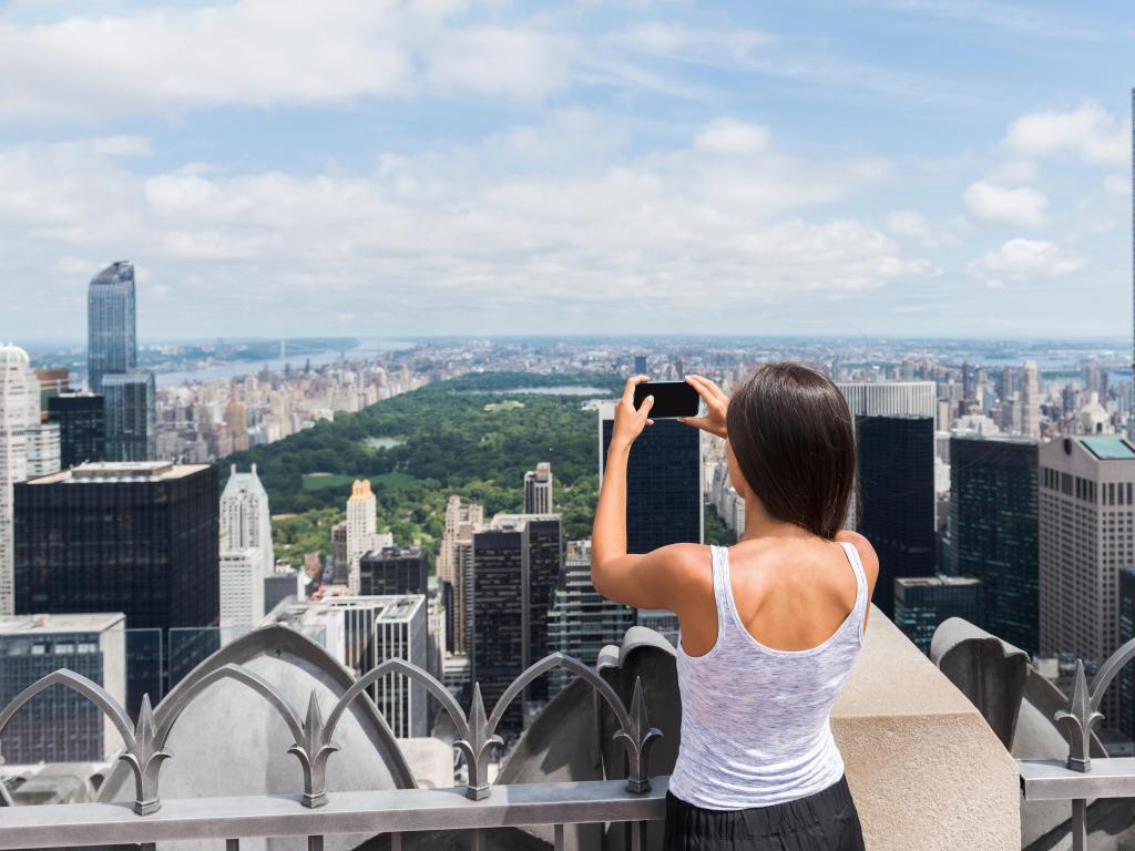 Woman taking photos of Manhattan from Top of the Rock, New York