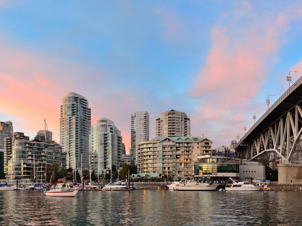 Vancouver False Creek panorama at sunset with bridge and boat. The photo is taken on a rather clear day and shows Vancouver's silhouette.