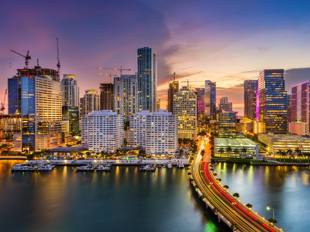 Miami, Florida, USA skyline on Biscayne Bay at evening with a stunning sky and the tall city buildings lit up.