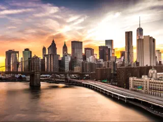 New York City Skyline at sunset with Brooklyn Bridge and Wall Street skyscrapers 