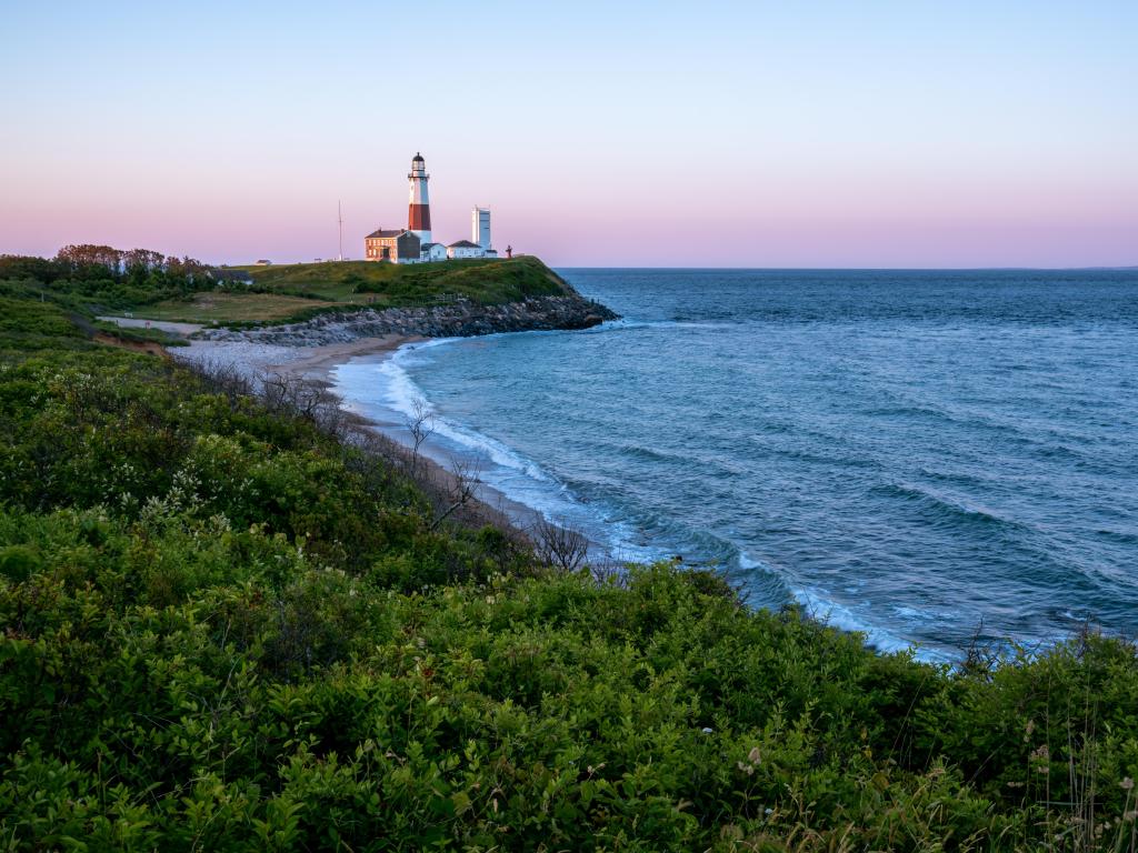 Montauk Lighthouse After Sunset, sitting on the shores of a wavy ocean