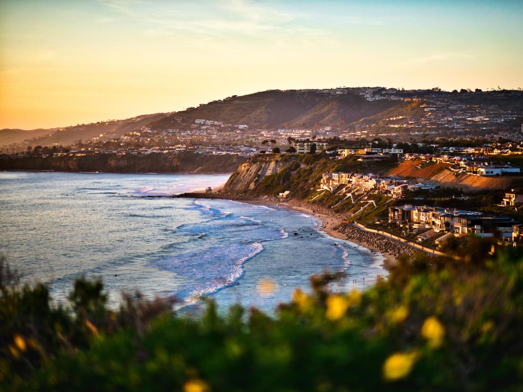 Dana Point, California, USA taken at sunset with a view of the coast and buildings along the cliffs.
