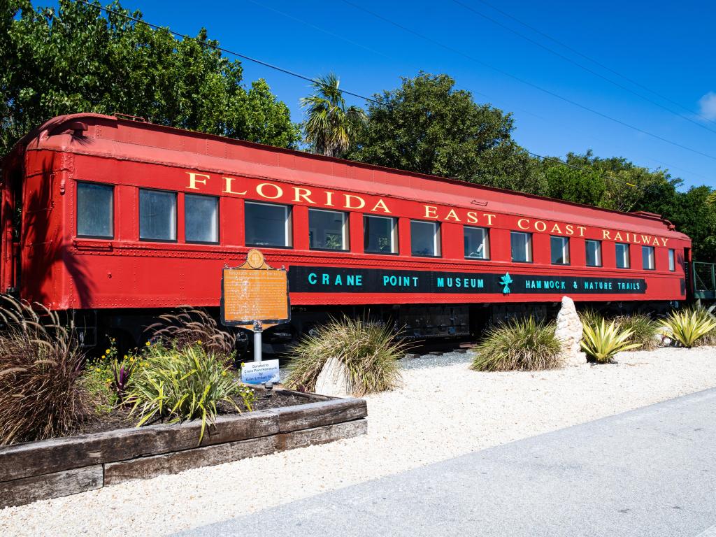 A red historic railway car on display at the Crane Point Museum. The train connected Key West to the mainland in the early 20th century.