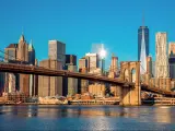 The Brooklyn Bridge with the early morning sunlight shining and some buildings on the background.