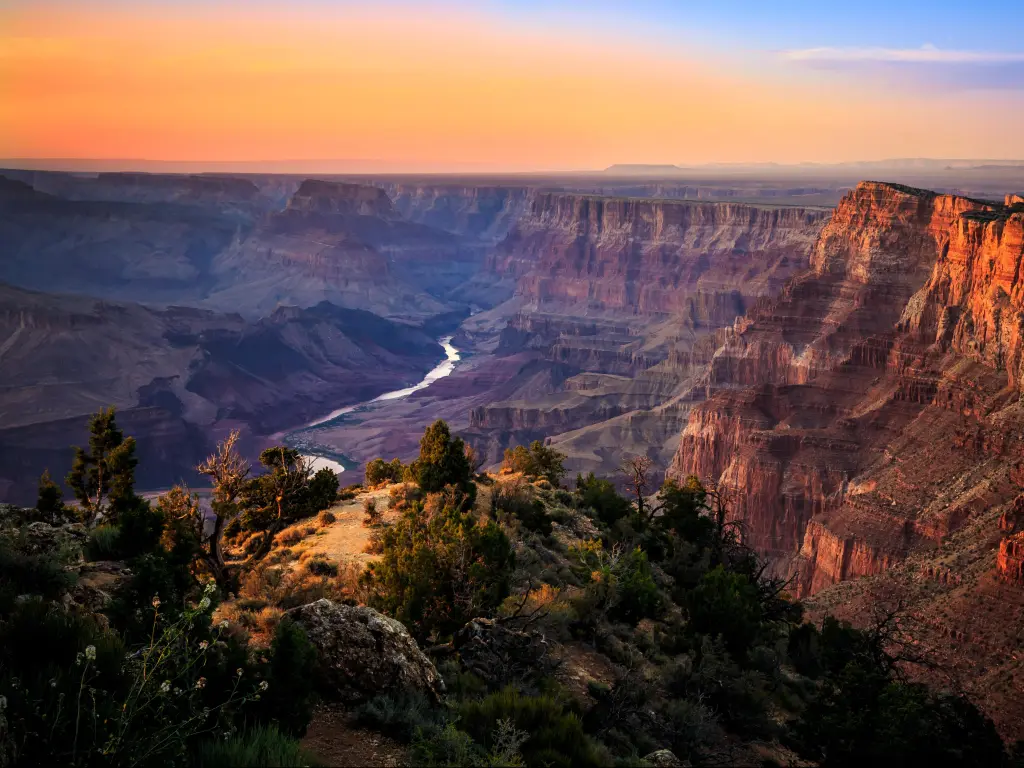 Grand Canyon National Park, Arizona, USA with a river running through the Grand Canyon at sunset.