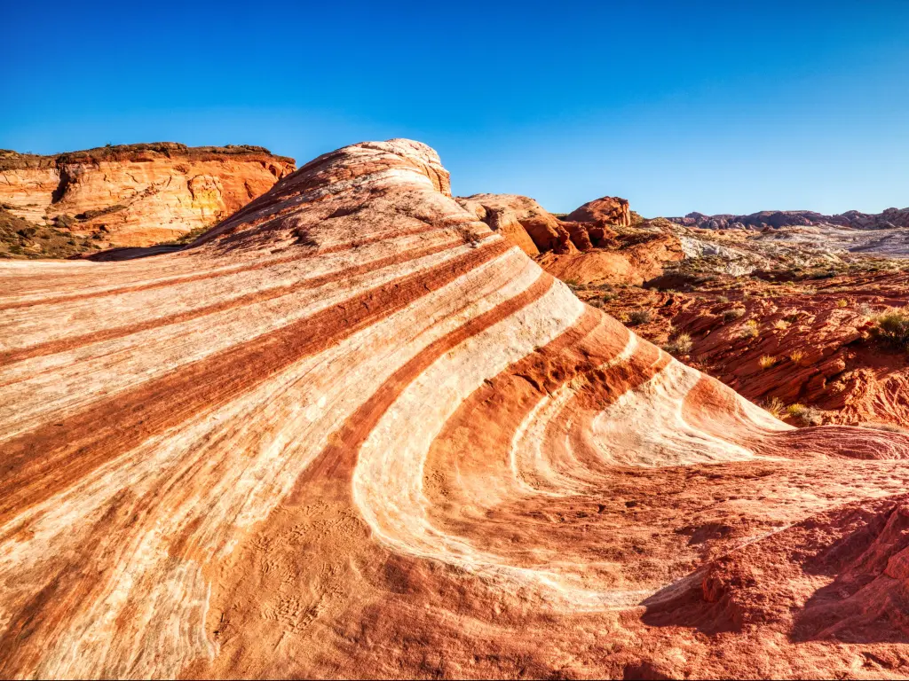 Valley Of Fire State Park, Nevada with fire waves in the rocks below a blue sky.
