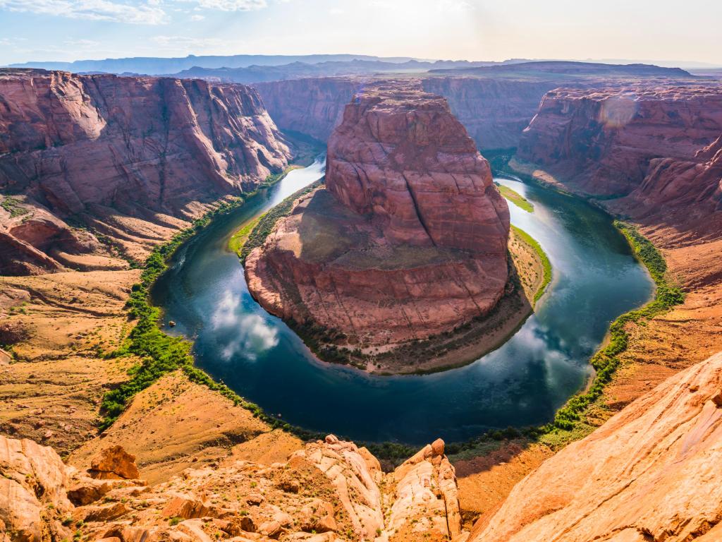 Horseshoe Bend, Page, Arizona, USA taken at the beautiful view of the Horseshoe Bend below, surrounded by red rock and the river with clouds reflecting in it. 