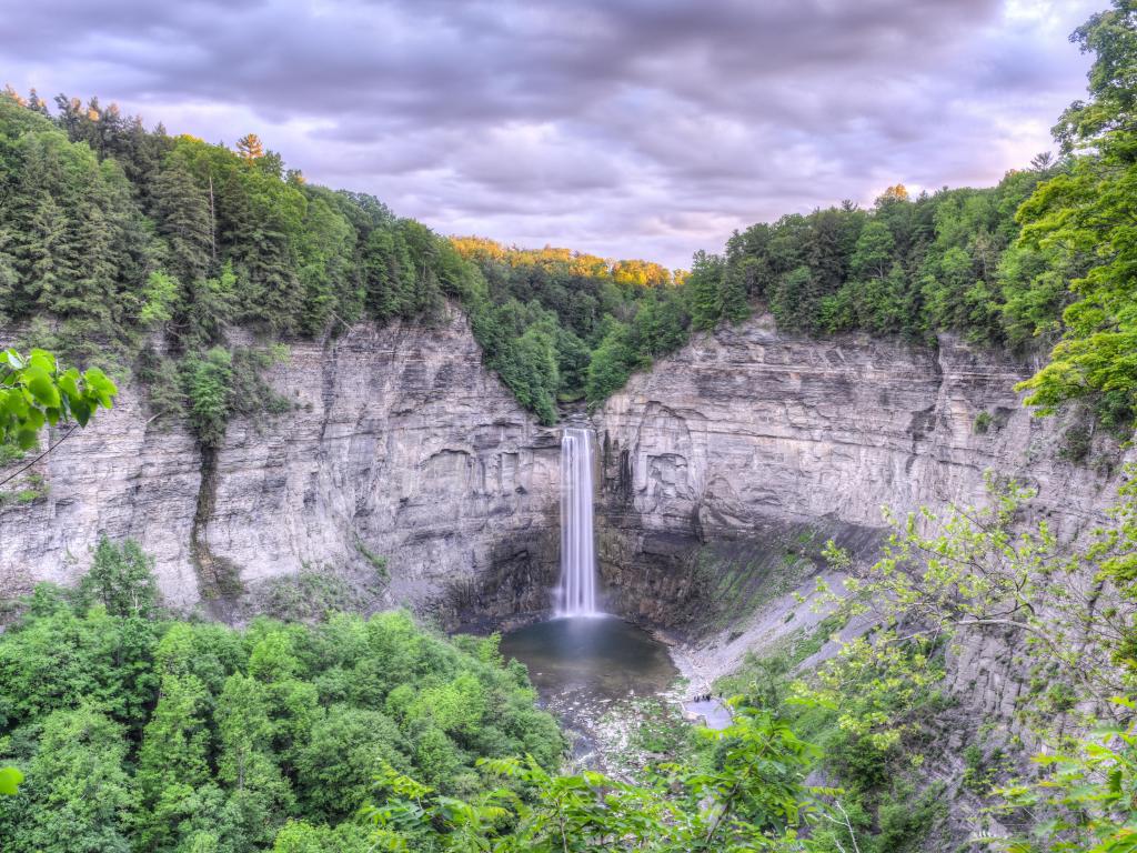 Taughannock Falls, Finger Lakes region of upstate New York, USA in the state park with a waterfall in the distance and trees surrounding.