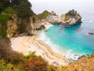 McWay cove, a beautiful sandy bay with blue waters and gushing waterfall into the ocean