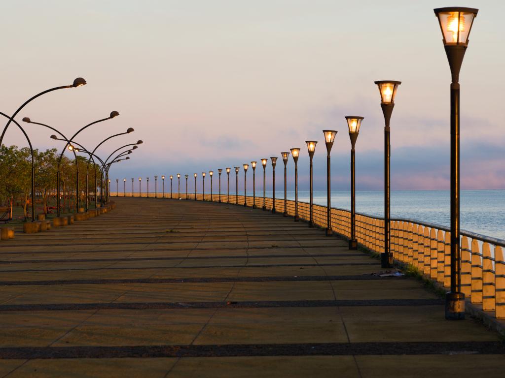 Sidewalk along Parana riverbank in Posadas, Misiones during early morning while the sun is still not up and the street lights are still on.