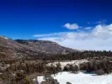 Colorado's Plateau and mesas in the background, covered in snow on a bright winter day