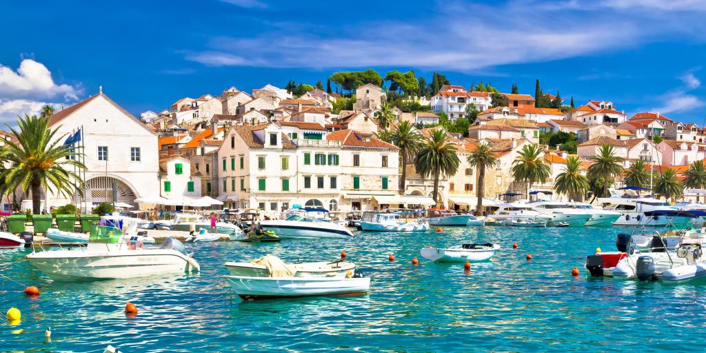 Boats in the turquoise water in the harbour of Hvar, Croatia, with white houses in the background