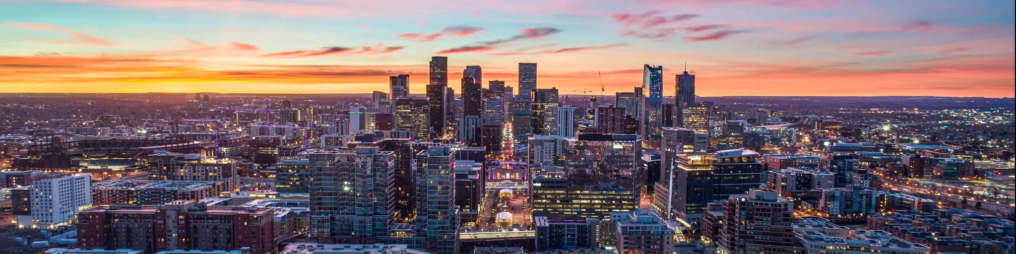 Downtown Denver, Colorado, USA. Drone skyline aerial panorama. The photo is taken at sunset and depicts a colorful sky behind the city skyline.