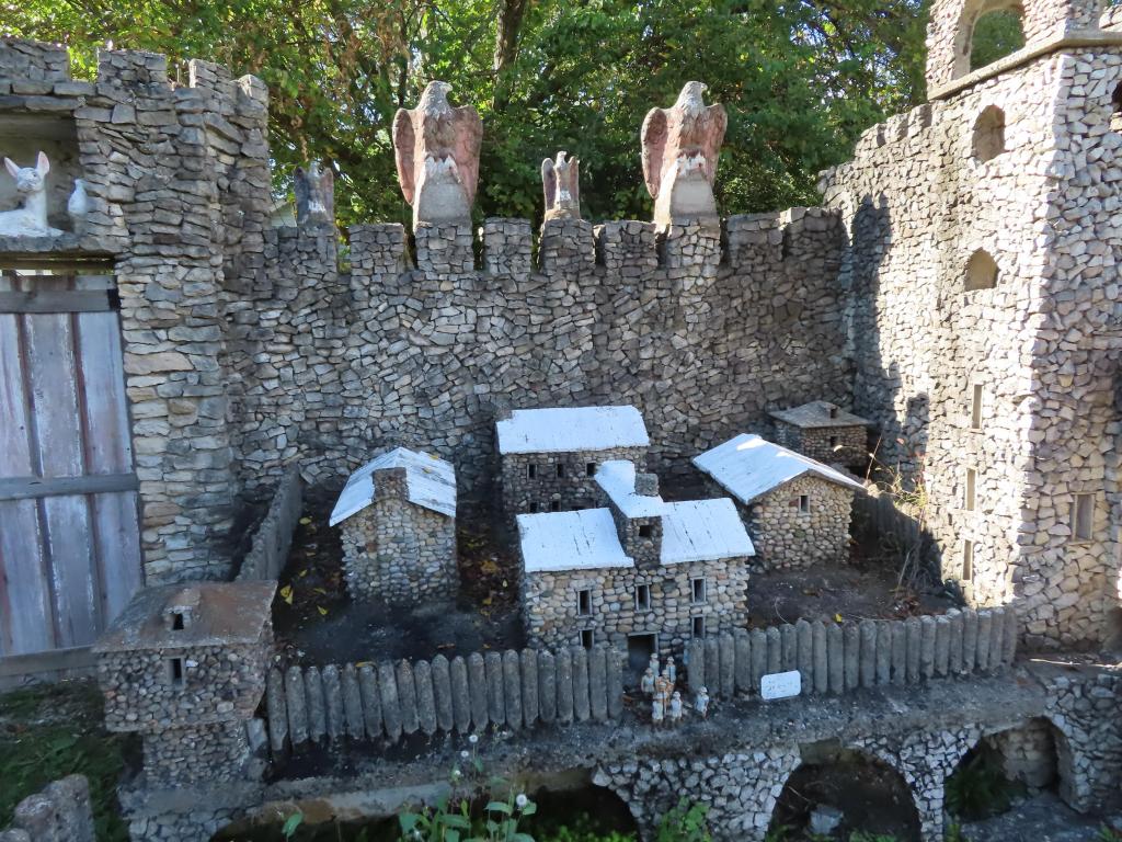 A castle sculpture built entirely out of rocks with small houses within the castle walls