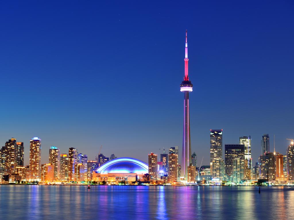 Toronto sunset over lake panorama with urban skyline.