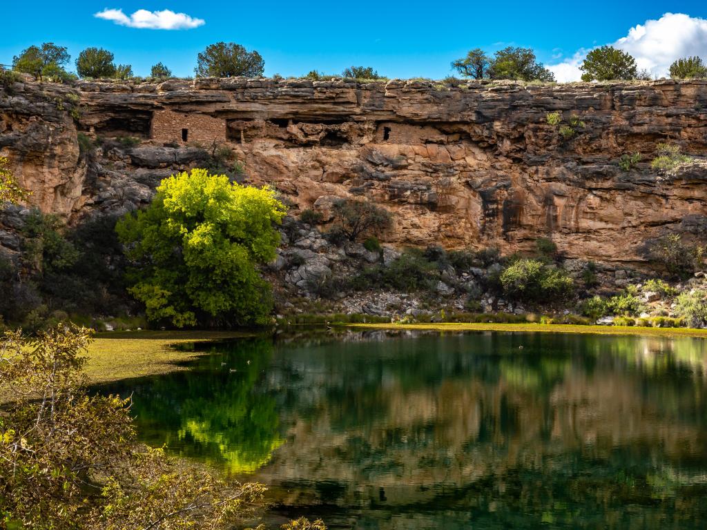 Ancient ruins and surroundings reflect on the quiet water of Montezuma Well with part of Montezuma Castle National Monument in Arizona, USA