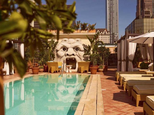 Stunning, stylish, rooftop pool, with plush seating and unusual dragon-face feature, with city views.