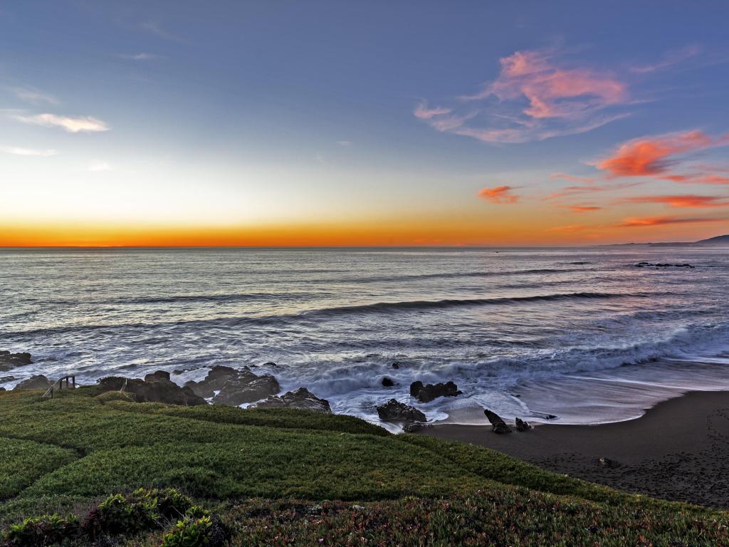 Golden hour, on the beach, painted sky and sea, waves crashing at sunset on Moonstone Beach