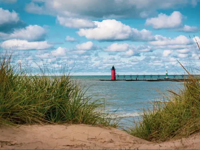 South Haven, Michigan, USA with dune grass in the foreground and the lighthouse and Lake Michigan in the distance.