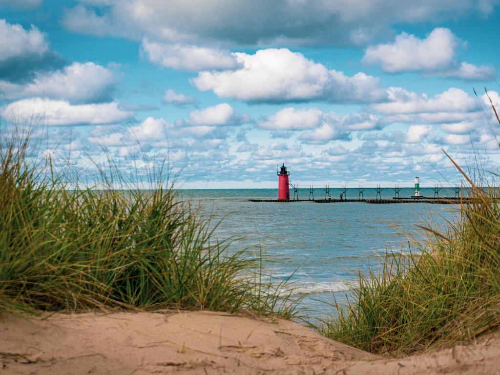 South Haven, Michigan, USA with dune grass in the foreground and the lighthouse and Lake Michigan in the distance.