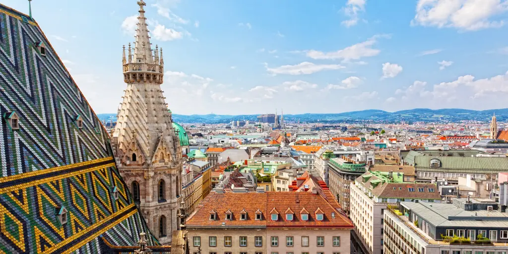 A cityscape view over Vienna, Austria, with the mosaic roof of St Stephen's Cathedral in the foreground