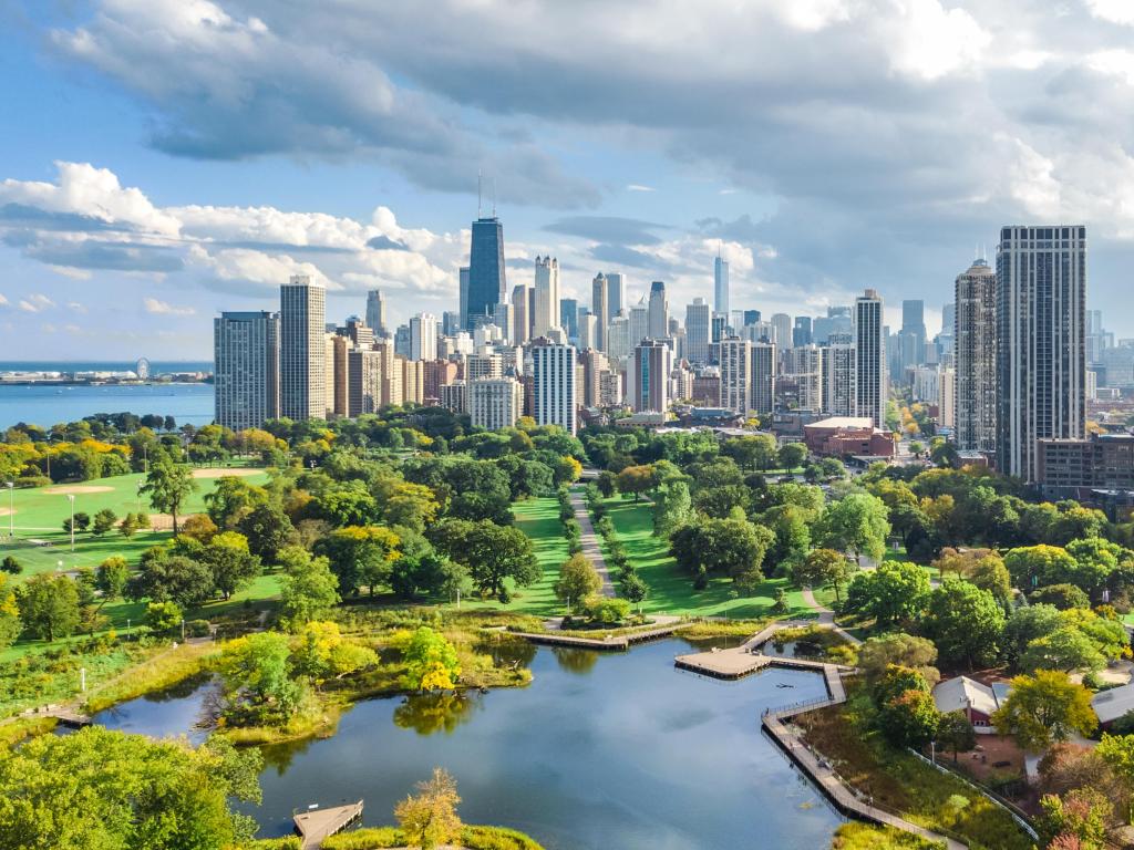 Chicago, Illinois, USA with the city skyline in the background and the stunning park and Lake Michigan in the foreground, taken as an aerial view from above, on a cloudy but sunny day. 