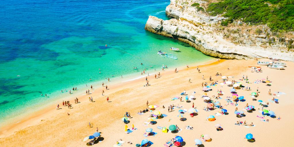 People relaxing on a beach in Portugal with the blue sea in the shot 