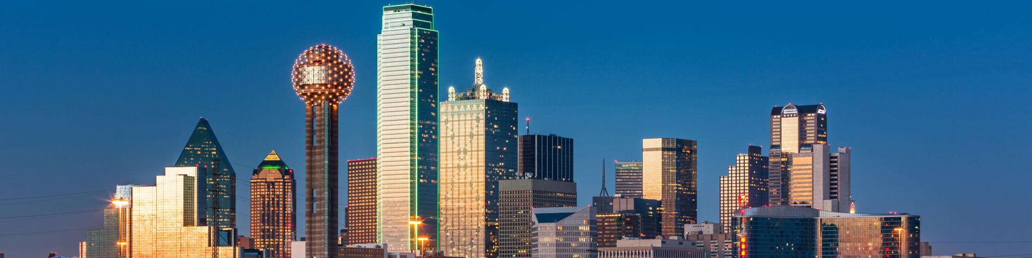 Dallas Texas Skyline with buildings reflected in the water and blue sky in the background