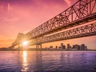 New Orleans, Louisiana, USA at Crescent City Connection Bridge over the Mississippi River during sunset.