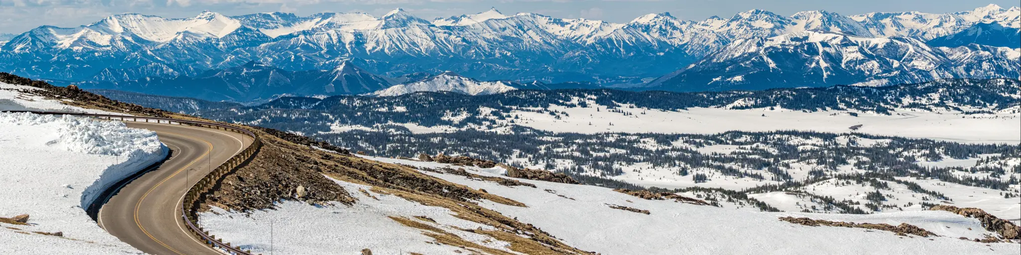 Panoramic view of snowy mountain ranges and highway along the Beartooth Scenic Highway. Montana and Wyoming, USA
