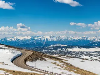 Panoramic view of snowy mountain ranges and highway along the Beartooth Scenic Highway. Montana and Wyoming, USA