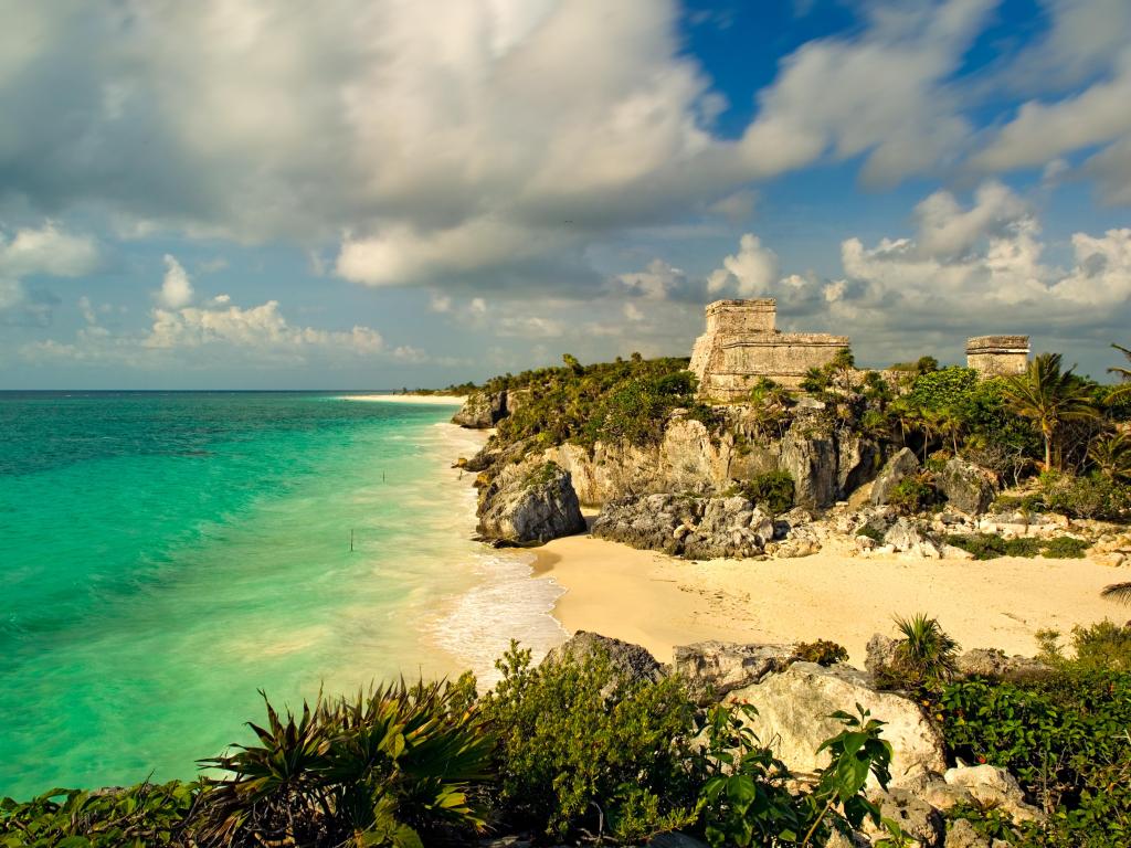 A 110-degree panoramic image of the main temple structure and Gulf of Mexico in the ancient Mayan city at Tulum, Mexico