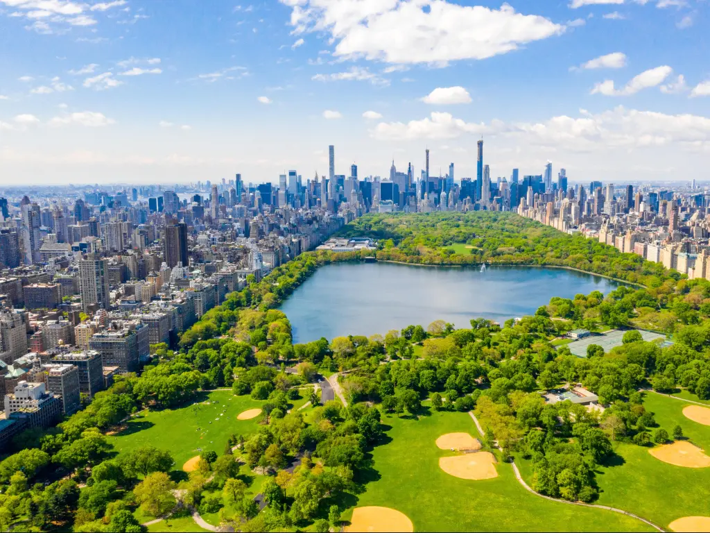 New York, USA with Central Park taken as an aerial view, surrounded by skyscrapers in the background and taken on a sunny day.