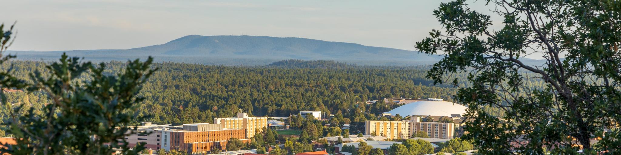 Aerial view over Flagstaff, Arizona, framed with forests and mountains in the distance