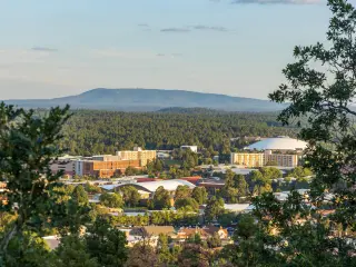 Aerial view over Flagstaff, Arizona, framed with forests and mountains in the distance