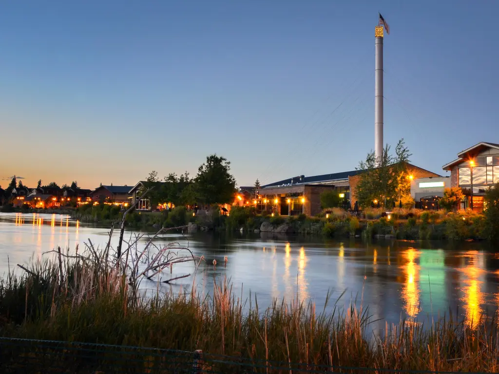Repurposed industrial buildings by the riverside in Bend during sunset