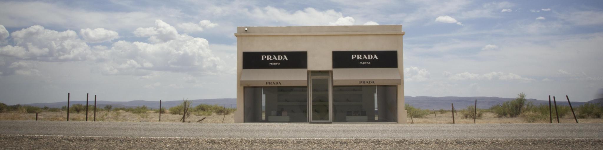  Prada store art installation near Marfa. Photo taken on a sunny day with a few clouds in the sky. The art installation building sits on the side of the highway.