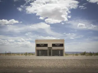  Prada store art installation near Marfa. Photo taken on a sunny day with a few clouds in the sky. The art installation building sits on the side of the highway.