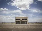  Prada store art installation near Marfa. Photo taken on a sunny day with a few clouds in the sky. The art installation building sits on the side of the highway.