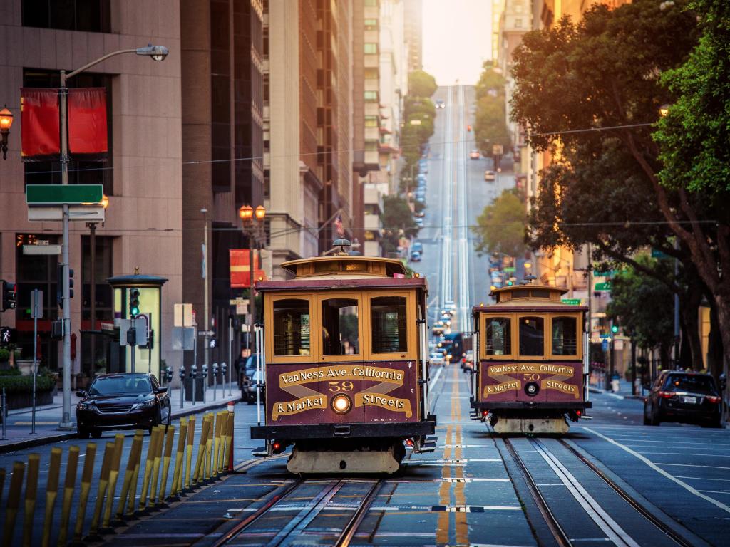 Classic view of historic traditional Cable Cars riding on famous California Street in morning light at sunrise with retro vintage style cross processing filter effect, San Francisco, California, USA