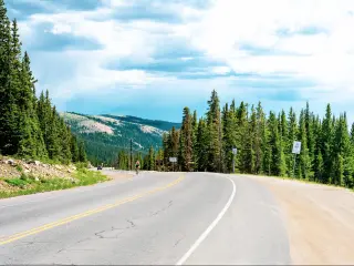 Cyclist on a bend on the Hoosier Pass en route to Breckenridge, Colorado, with mountains in the background