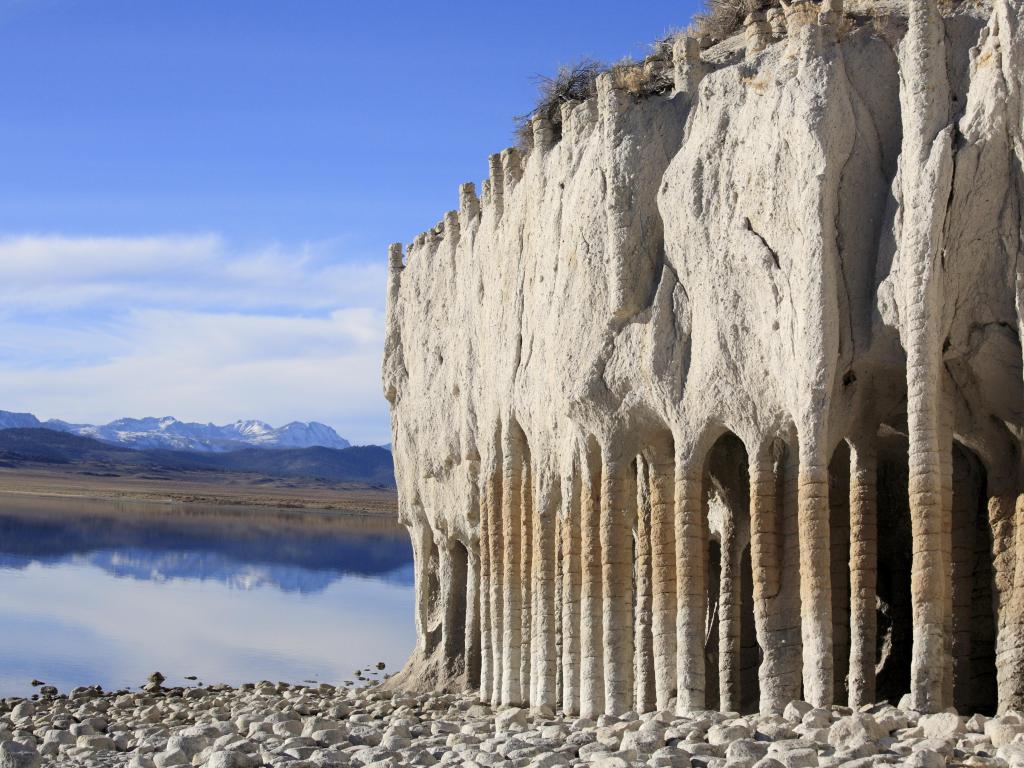 The unique white rock formations of Crowley Lake Columns rise from the pebbly shoreline in California