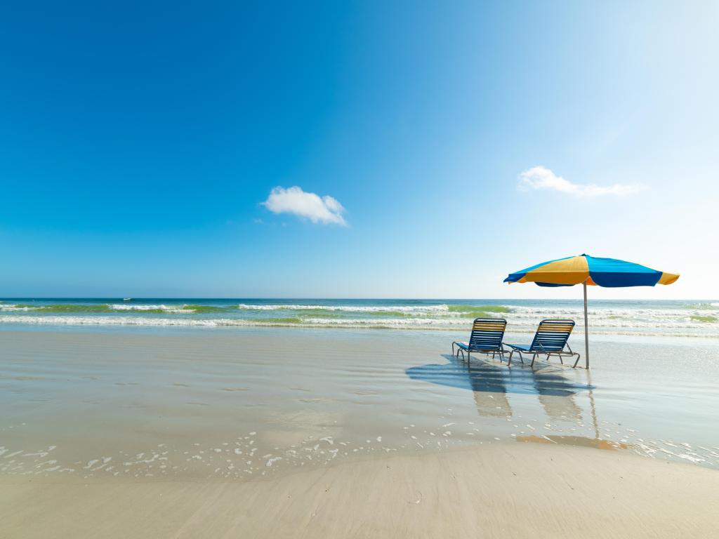 Parasol and beach chairs on the foreshore in Daytona Beach. Florida, USA