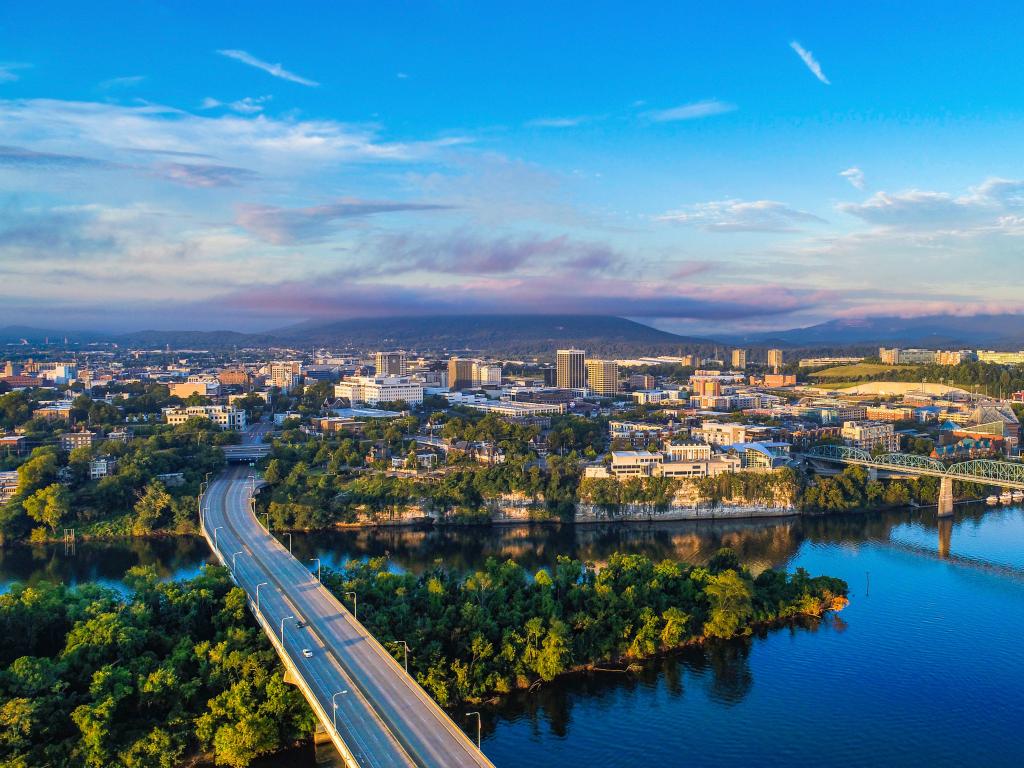 Chattanooga, Tennessee, USA with a drone aerial view of downtown Chattanooga and the Tennessee River on a sunny day.