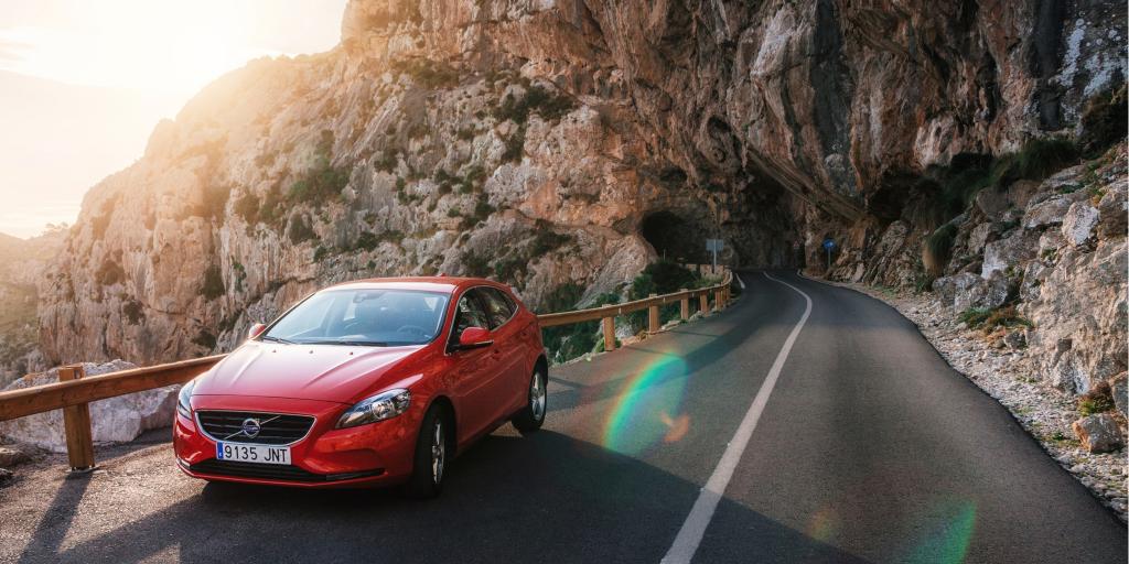 A red car driving on the right in the mountains in Spain 