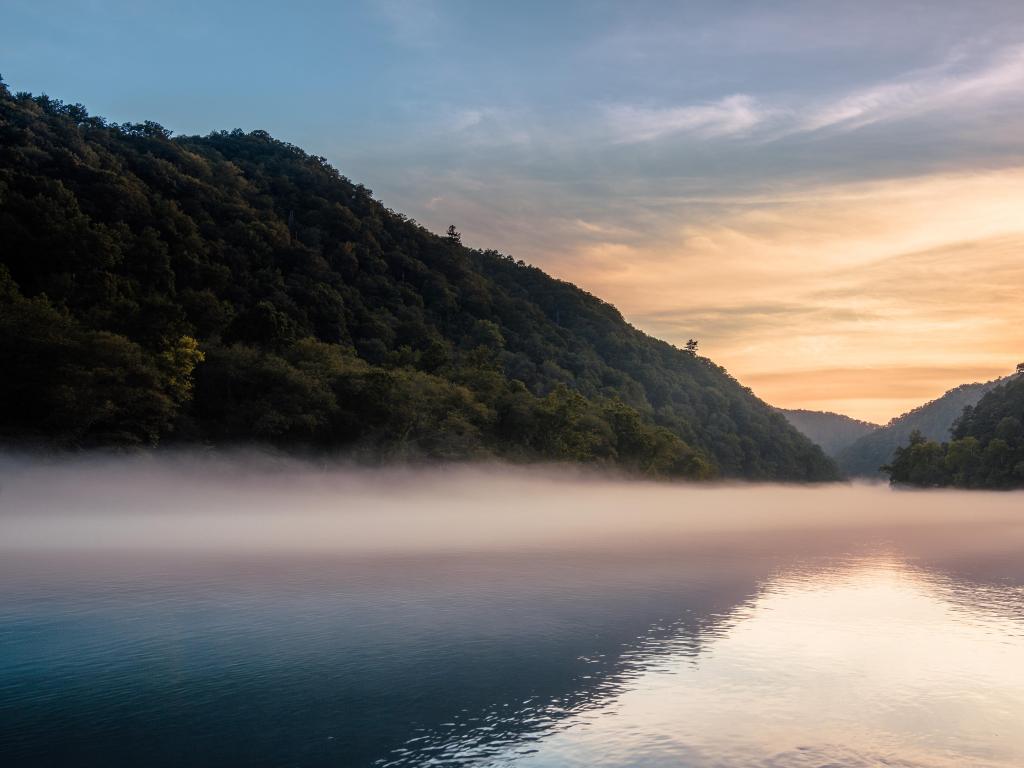 Cheoah Lake, Great Smoky Mountains, USA with a misty lake view and sunset.