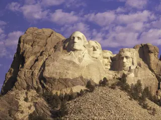 Mount Rushmore, South Dakota, with blue sky and puffy clouds behind