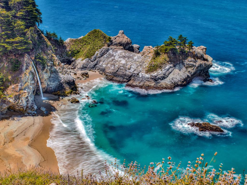 Beautiful McWay Falls descending on the beach on a sunny day