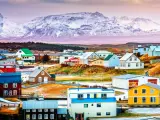  Colorful Icelandic houses with the backdrop of a majestic, snow-covered mountain, pink misty hue surrounding it