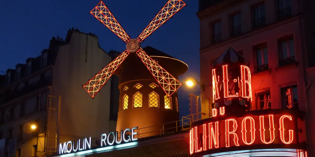 The neon lights of the Moulin Rouge lit up in the evening in Paris